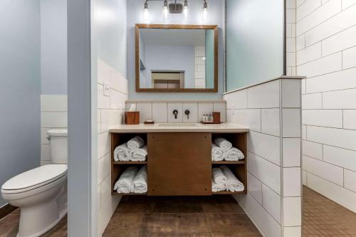 bagno con lavandino, servizi igienici e specchio di The Cranberry, Ascend Hotel Collection a Morgantown