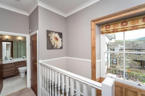 ein Badezimmer mit Badewanne und Toilette und einem Fenster in der Unterkunft Bridge Cottage in Keswick