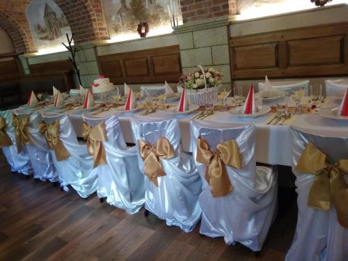 a row of tables with white chairs with bows at Nábřežní terasy in Žďár nad Sázavou