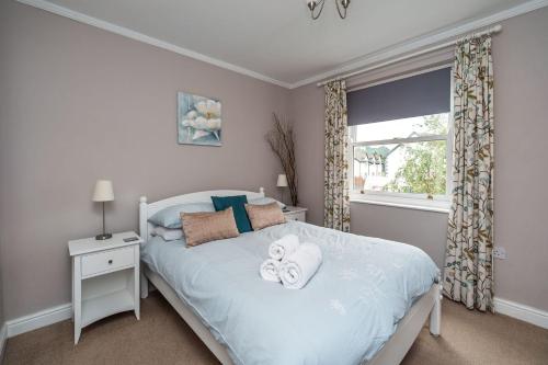 um quarto com uma cama branca e toalhas em Coledale em Keswick