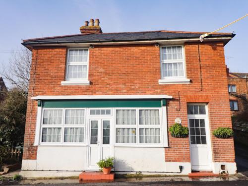 a red brick house with a white garage at Old Post Office in Ashford