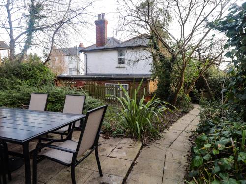 a table and chairs in front of a house at Old Post Office in Ashford