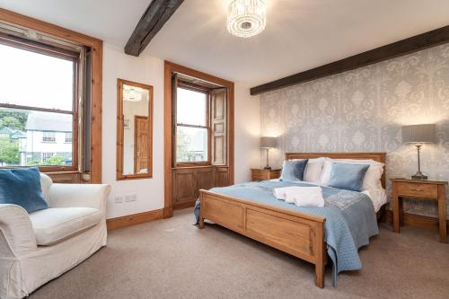 um quarto com uma cama, um sofá e uma cadeira em Bridge House Apartment 2 em Keswick