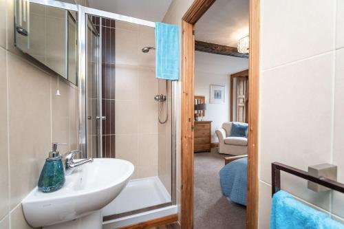 uma casa de banho com um lavatório branco e um chuveiro em Bridge House Apartment 2 em Keswick