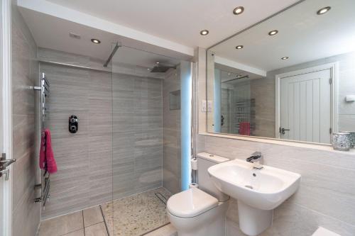 a bathroom with a sink and a toilet and a mirror at Bridge Mews in Keswick
