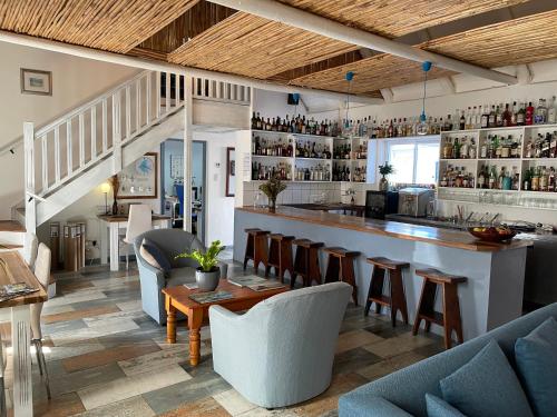 a bar in a restaurant with chairs and a counter at BlueSky Arniston Guest House in Arniston