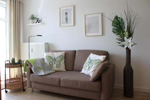 a living room with a couch and a plant at Residenz Haffblick Wohnung 31 in Boltenhagen