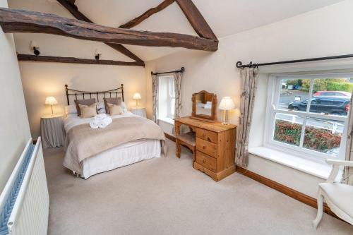 a bedroom with a bed and a window at Jasmine Cottage in Portinscale