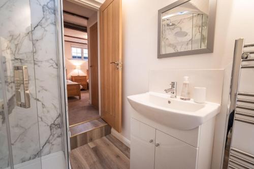a bathroom with a sink and a shower at Daisy Cottage in Keswick
