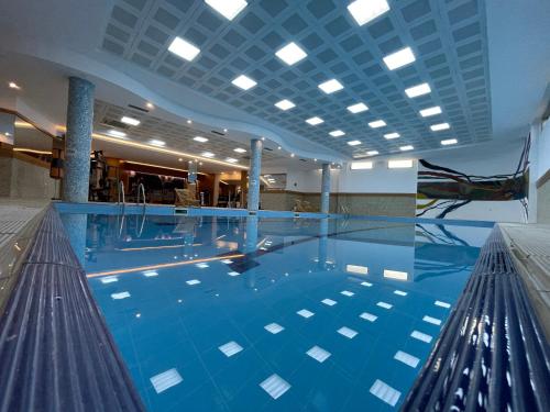 a large swimming pool with blue water in a building at Van Royal Hotel in Erbil