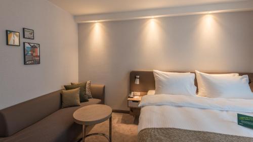 a hotel room with a bed and a couch at Holiday Inn - Hamburg - Berliner Tor by IHG in Hamburg