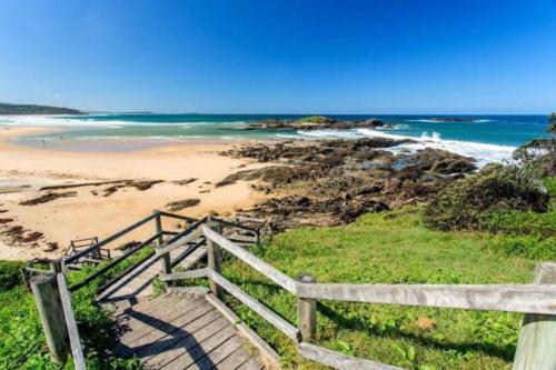 a staircase leading to a beach with the ocean at Emma’s Place in Sawtell