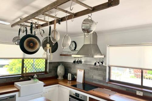 a kitchen with pots and pans hanging from the wall at Emma’s Place in Sawtell
