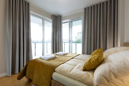 1 dormitorio con cama y ventana grande en Apartament Perłowe Tarasy, en Sarbinowo