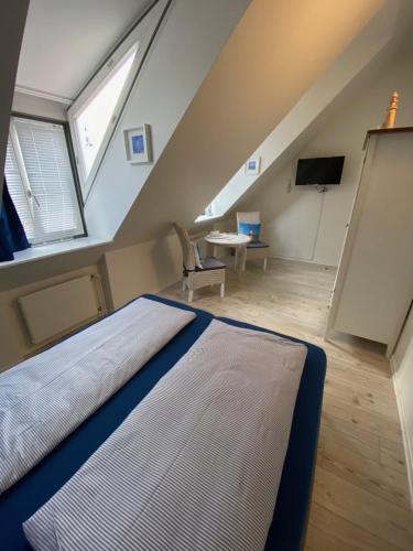 a attic bedroom with a bed and a tv at Gästehaus Lavendel in Flensburg