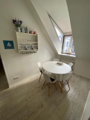 a white dining room with a white table and chairs at Gästehaus Lavendel in Flensburg