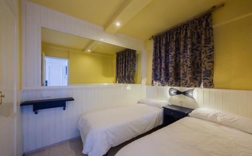 a hotel room with two beds and a window at Apartamentos Teneguia in Puerto de la Cruz