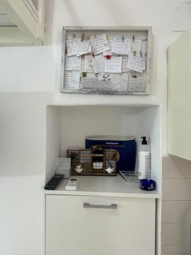 a small white cabinet with papers on a wall at Casetta Rosy in Ostuni