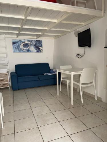 a living room with a blue couch and a table at Casetta Rosy in Ostuni