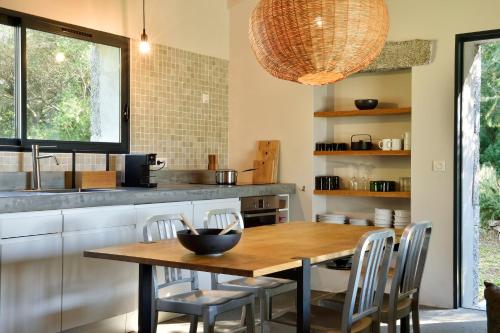 a kitchen with a wooden table and chairs at Domaine de Peretti della Rocca in Figari