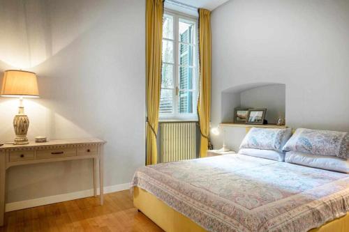 een slaapkamer met een bed en een tafel met een lamp bij LISOLA Appartamento con vista lago in Orta San Giulio