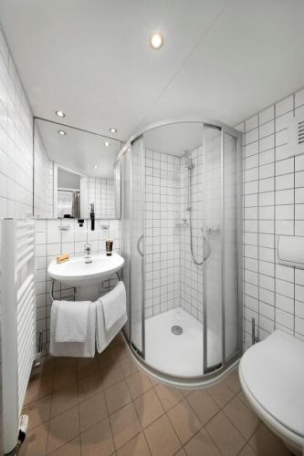 a bathroom with a shower and a sink and a toilet at KNAUS Campingpark Leipzig in Leipzig