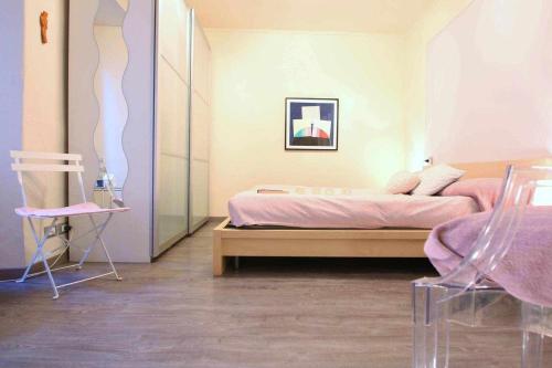 - une chambre avec un lit et une chaise dans l'établissement LA PERLA piccolo appartamento in piazza, à Orta San Giulio