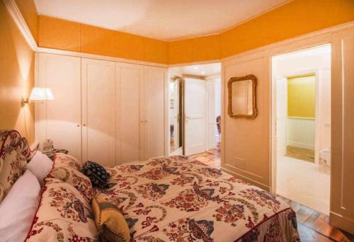 a bedroom with a bed with a flowered blanket at Casa Orta appartamento con vista lago in Orta San Giulio