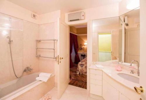 bagno con vasca, lavandino e doccia di Casa Orta appartamento con vista lago a Orta San Giulio