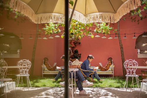 a group of people sitting on chairs under an umbrella at toctoctoc lisboa in Lisbon