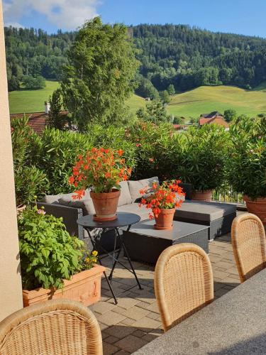 a patio with a table and chairs and flowers at B&B Quartenoud in Treyvaux
