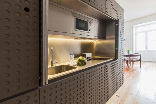 a kitchen with a sink and a microwave at bnapartments Loftpuzzle in Porto
