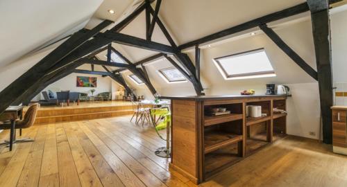 ein Wohnzimmer mit Holzboden und einer Balkendecke in der Unterkunft Spacious duplex in Brussels Historical Center in Brüssel