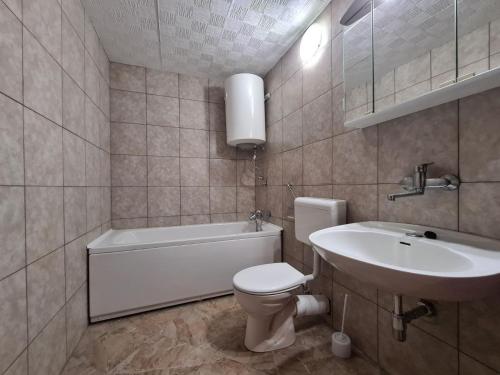 a bathroom with a white toilet and a sink at House Krnica 2120 in Krnica