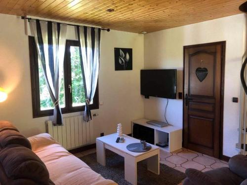 a living room with a couch and a table at Ma Jolie Camyna in Ramonchamp