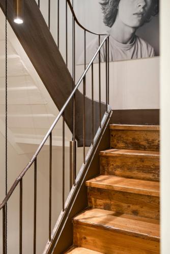 a staircase with wooden steps and a picture of a woman at toctoctoc lisboa in Lisbon