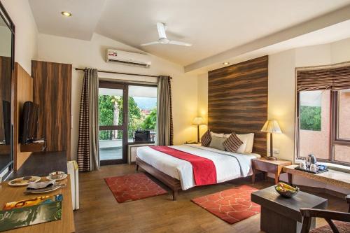 a bedroom with a bed and a living room at The Riverview Retreat Corbett by Leisure Hotels in Garjia