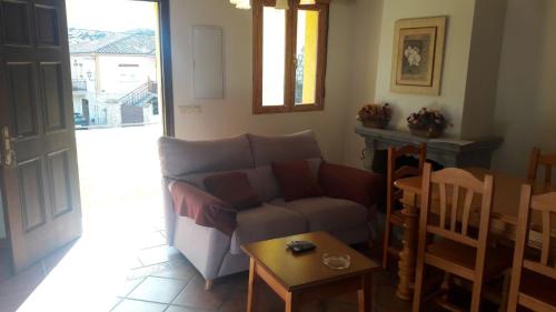 uma sala de estar com um sofá e uma mesa em Casa Rural los Portalillos I em Navatalgordo