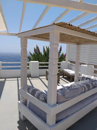 a pergola on a patio with the ocean in the background at Aigeis-milos in Agia Kiriaki Beach