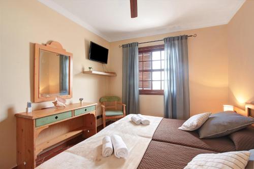 a bedroom with a bed with a dresser and a mirror at Rincón de Daute in Los Silos