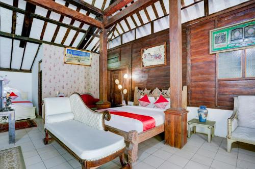 a bedroom with a bed and two chairs in a room at OYO 90363 Nira Guest House Sanur Bali in Sanur