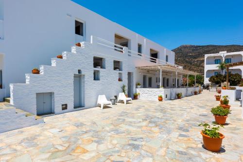 a large white building with a stone courtyard at Ammos Sifnos Village in Platis Yialos Sifnos