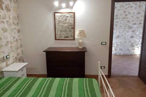 Schlafzimmer mit einem Bett, einer Kommode und einem Spiegel in der Unterkunft Casa vacanze Krimisòs in Castellammare del Golfo