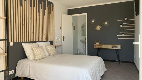 een slaapkamer met een wit bed en een zwarte muur bij Villa Maya in Lambesc