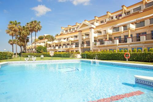 una gran piscina frente a un edificio en Romana Playa 637, en Marbella