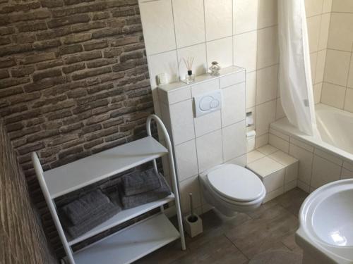 biała łazienka z białą toaletą i umywalką w obiekcie Pension Heidschnucke w mieście Schneverdingen