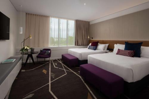 pokój hotelowy z dwoma łóżkami i telewizorem w obiekcie Rydges Campbelltown w mieście Campbelltown