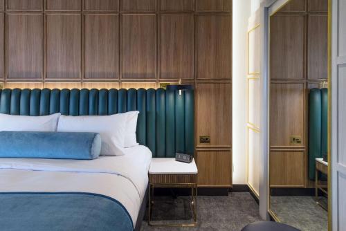 a bedroom with a bed and a green headboard at Powerhouse Hotel Tamworth by Rydges in Tamworth