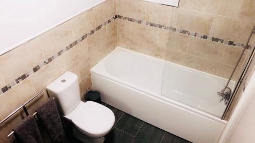 a bathroom with a toilet and a tub and a sink at Market in Elsecar