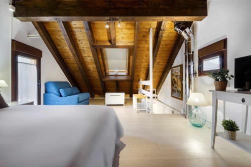 1 dormitorio con 1 cama y 1 silla azul en una habitación en Casa Santiago alojamientos rurales en Panticosa, en Panticosa